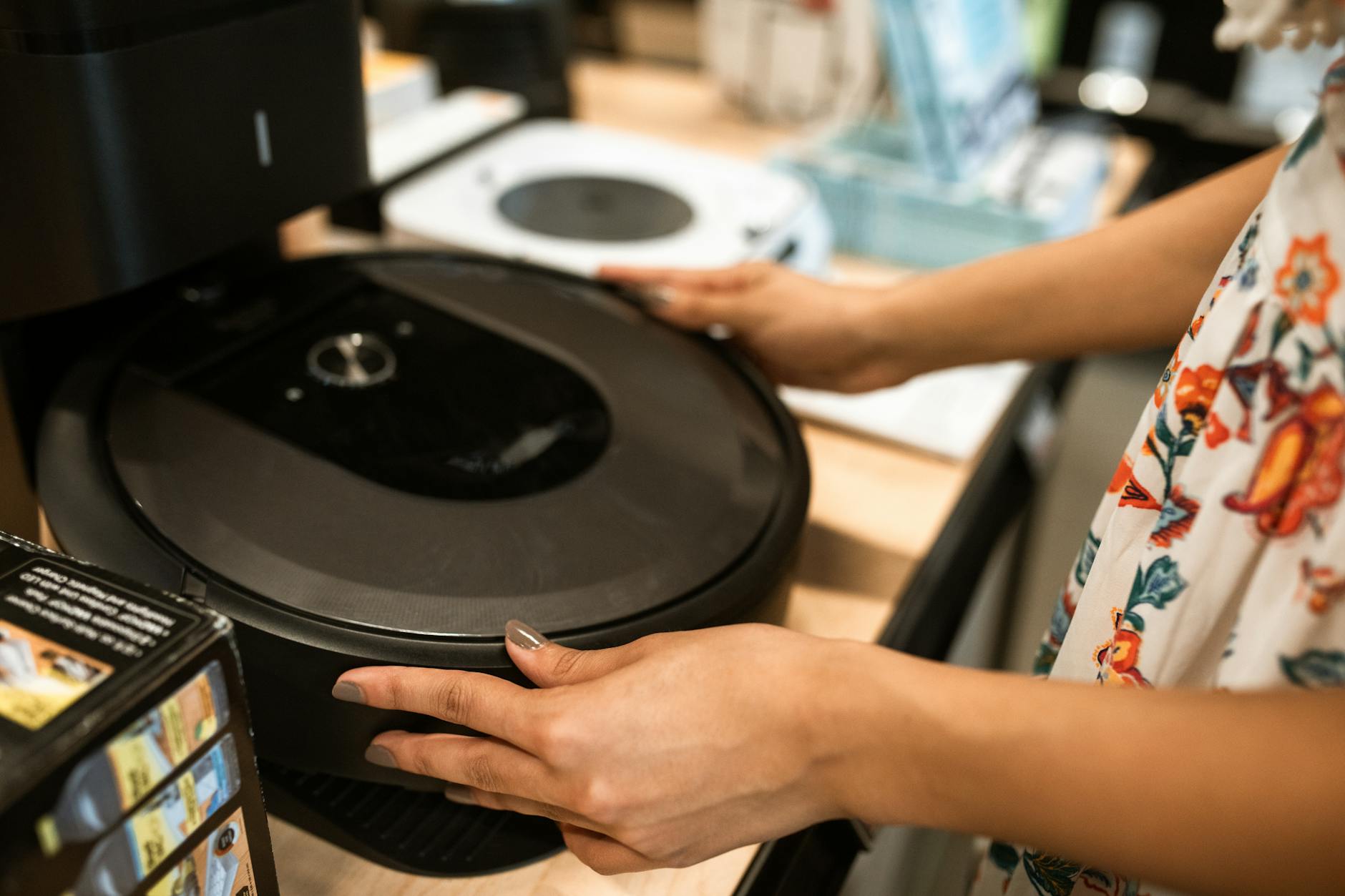 Klient ogląda nowy robot sprzątający w nowoczesnym sklepie RTV