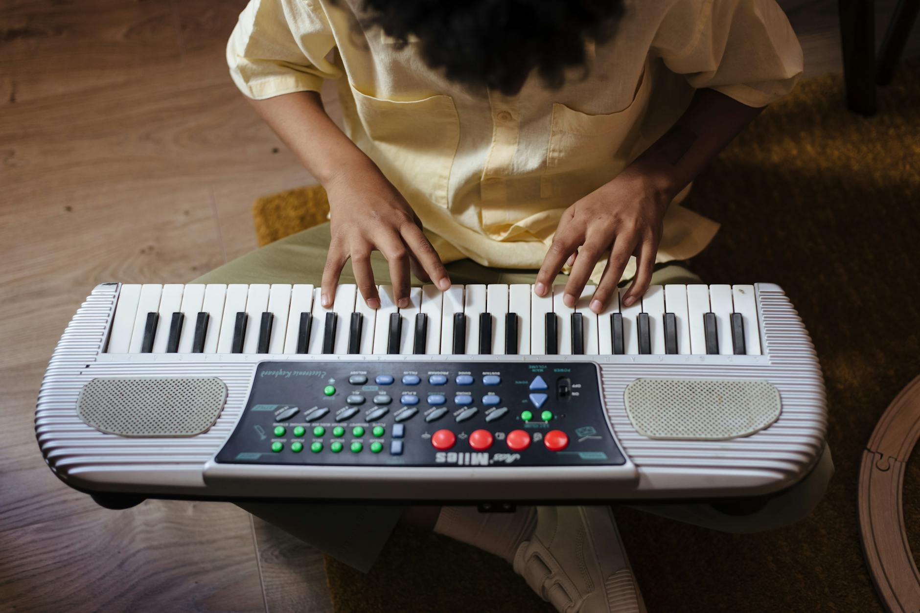 Dziecko ćwiczące grę na małym keyboardzie w domu