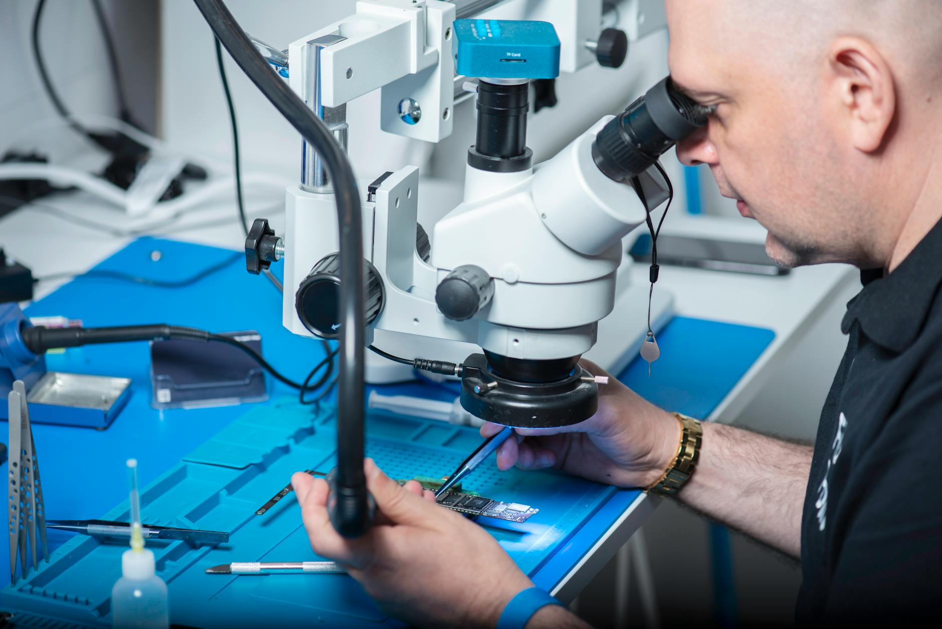 Serwisant sprawdza pod mikroskopem układ elektroniczny w laboratorium