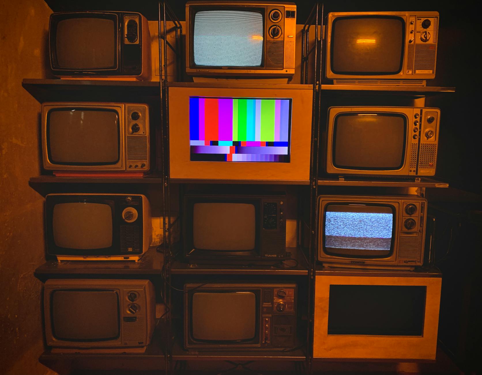 Ranking: najlepsze telewizory powystawowe do 2000 zł w 2026 roku Stare telewizory z kolorowymi planszami testowymi i śnieżeniem na ekranach