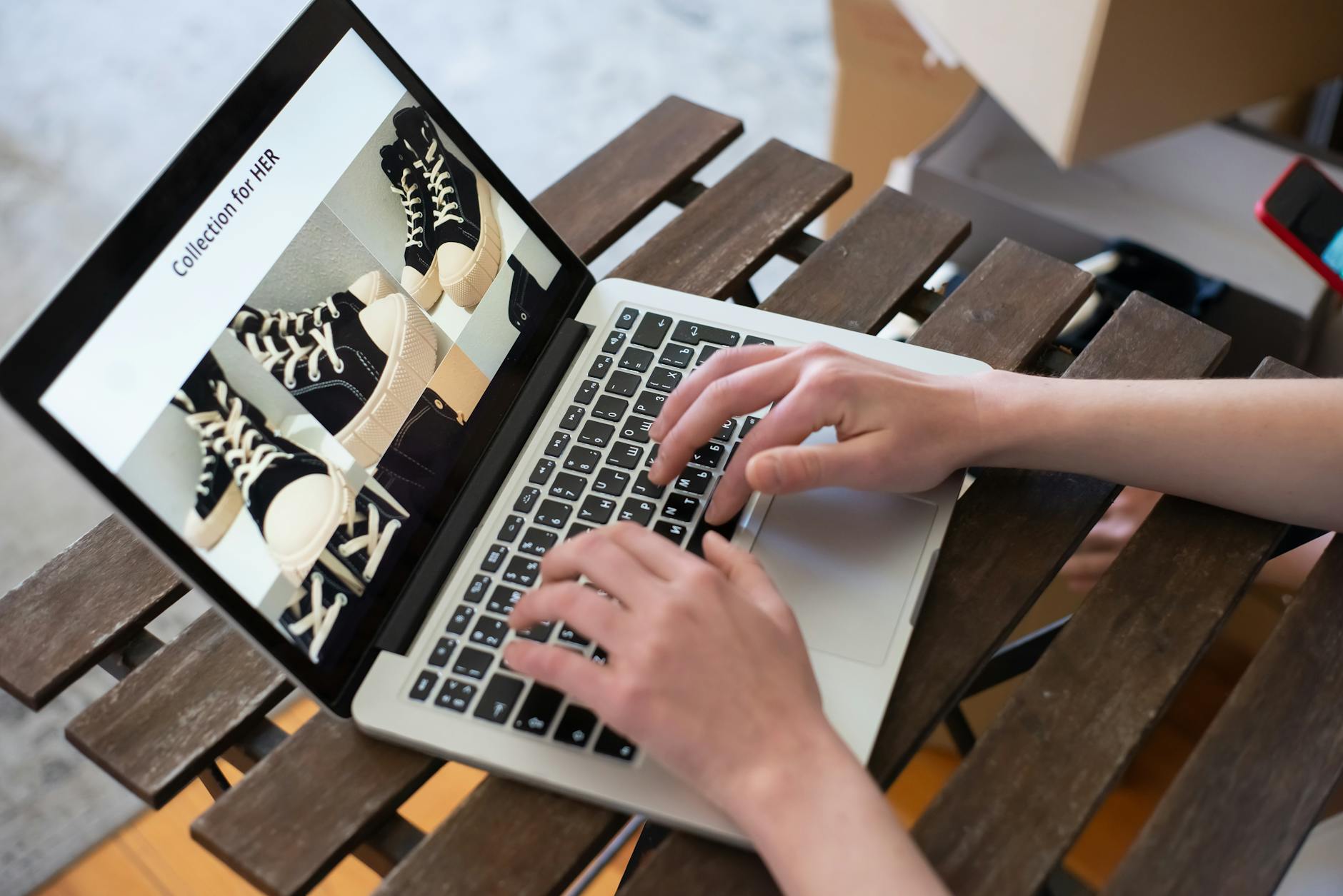 Osoba przegląda damskie buty w sklepie internetowym na laptopie