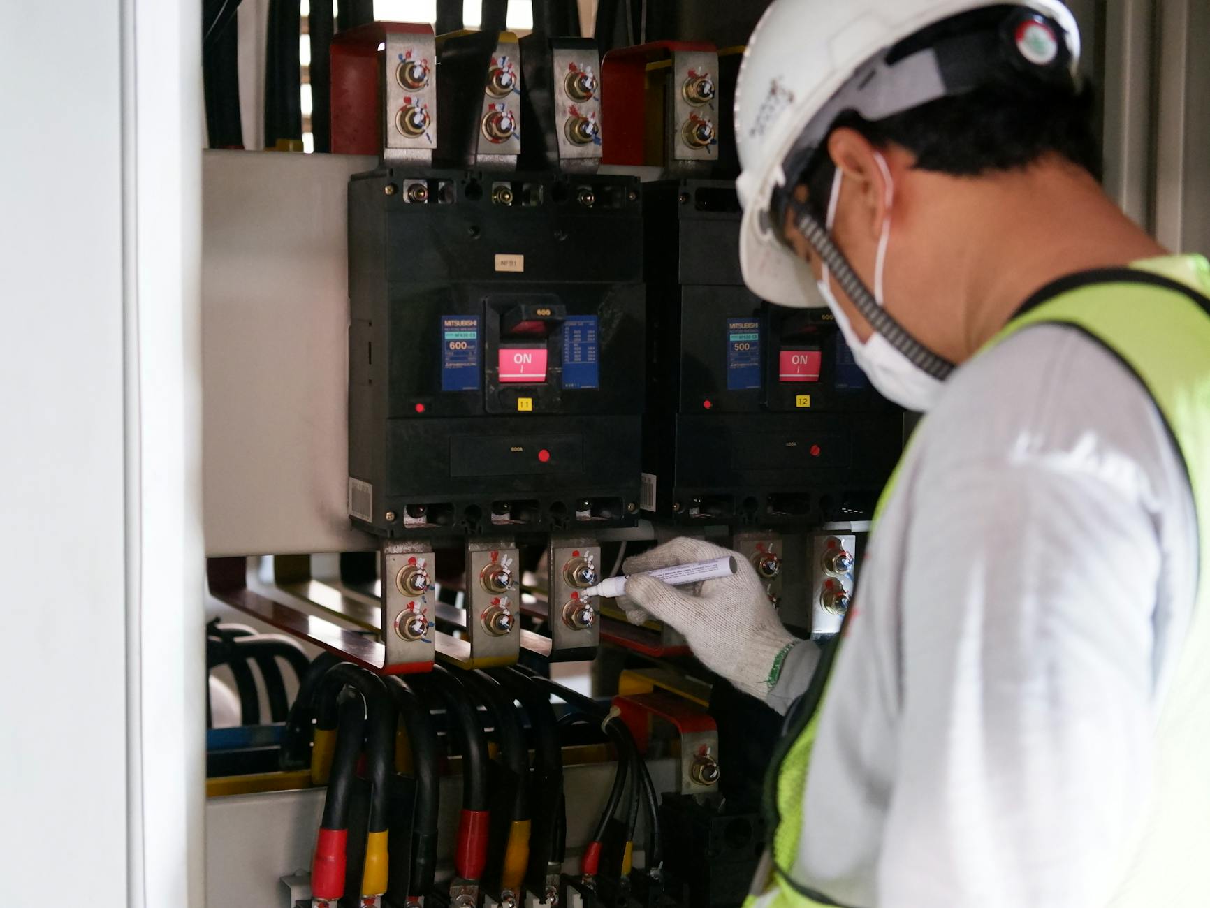 Serwisant w odzieży ochronnej sprawdza panel elektryczny przy lodówkach Bosch