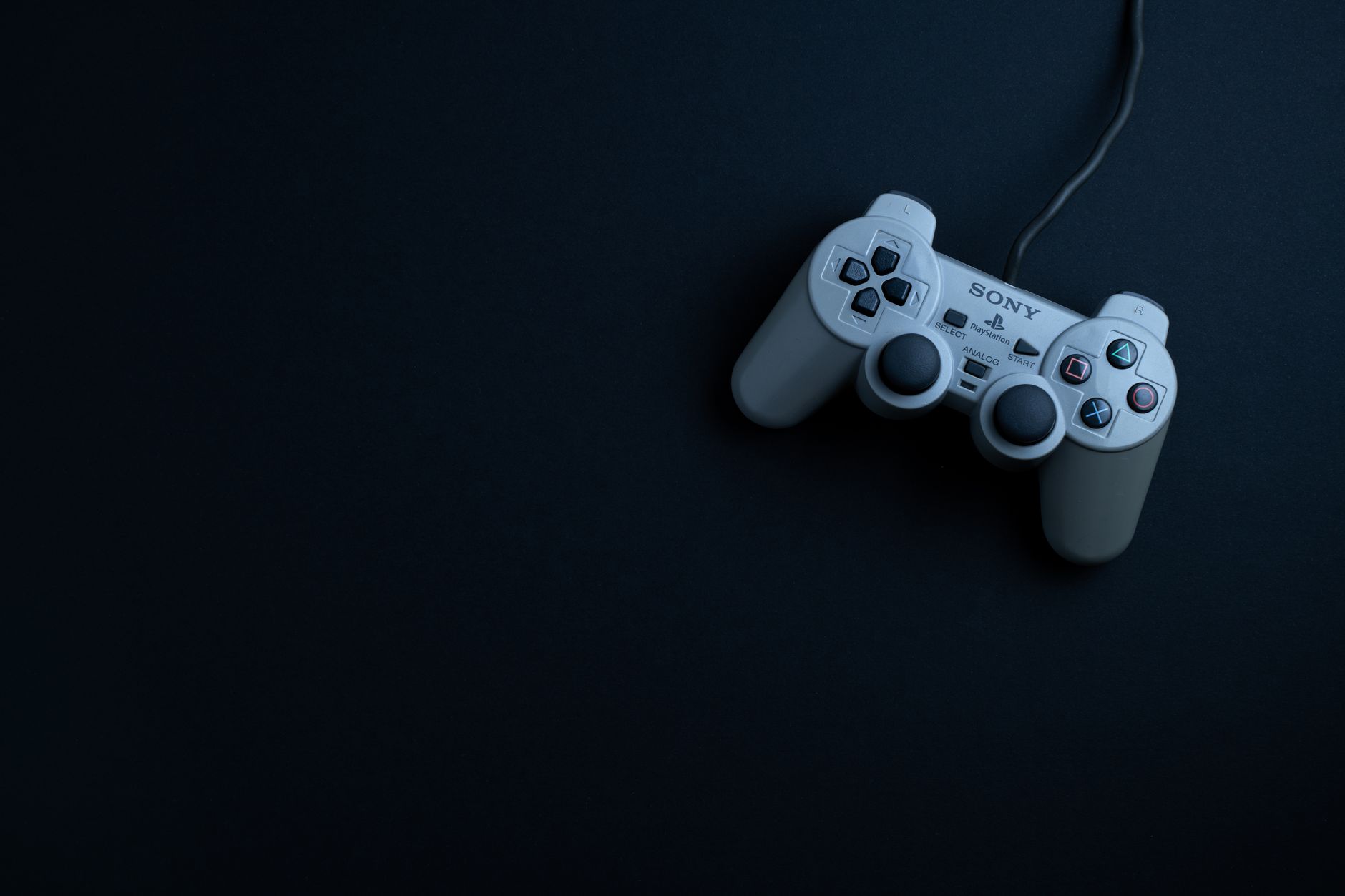 Klasyczny gamepad widziany z góry na ciemnym tle