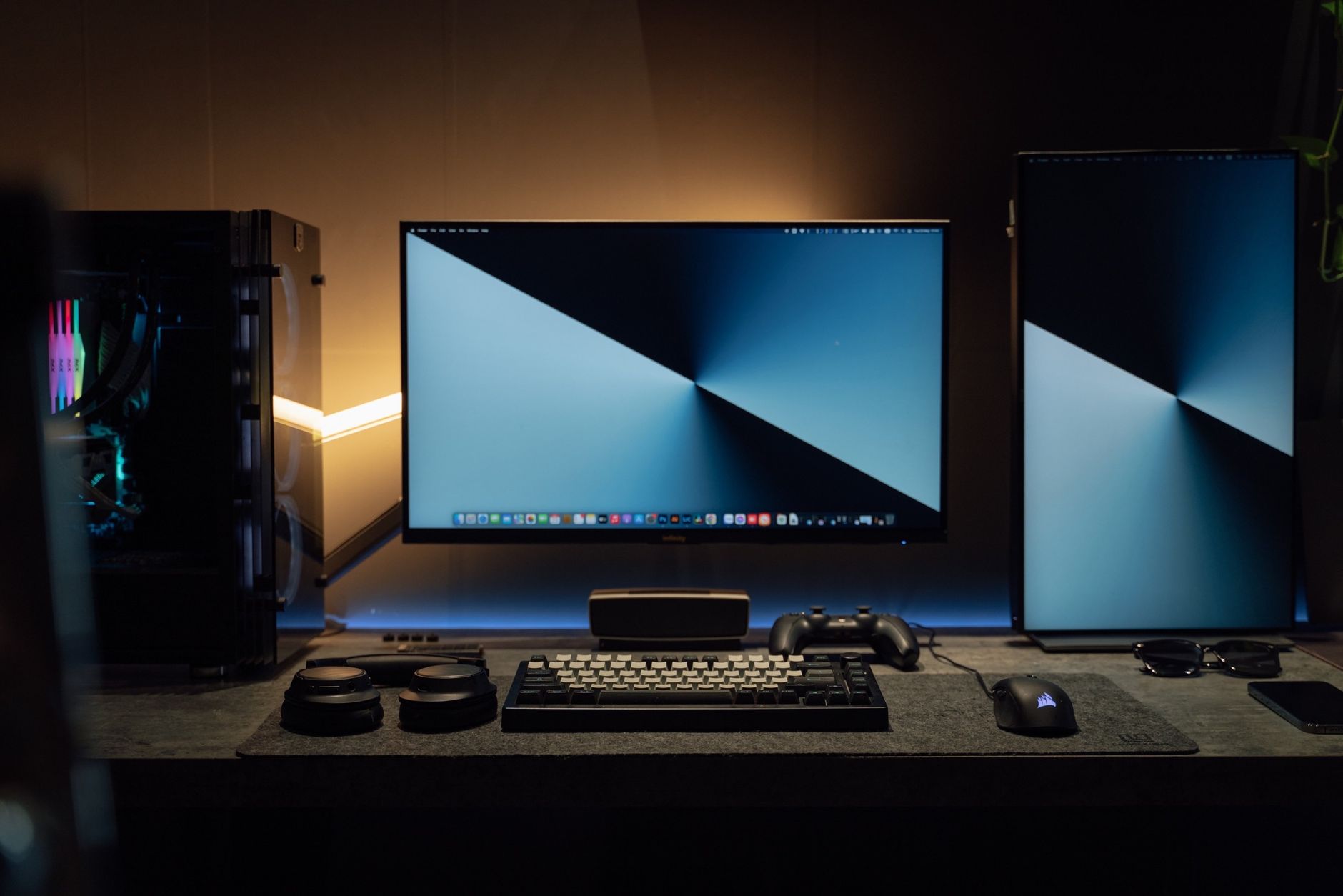 Ciemne biurko komputerowe z dwoma monitorami i akcesoriami gamingowymi