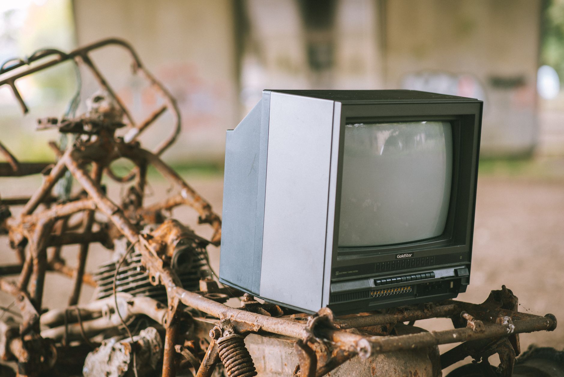 Stary czarny telewizor pod betonowym mostem na zardzewiałej konstrukcji Stary czarny telewizor pod betonowym mostem na zardzewiałej konstrukcji